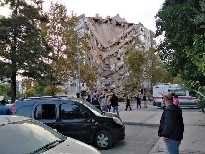 Locals look at a damaged building in Izmir